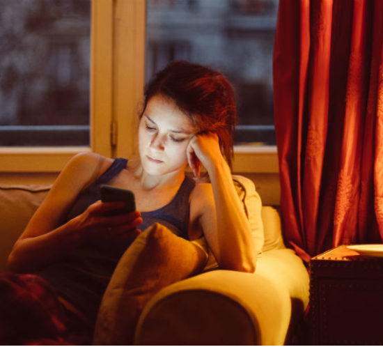 Woman in living room on phone for Find Insurance NI blog