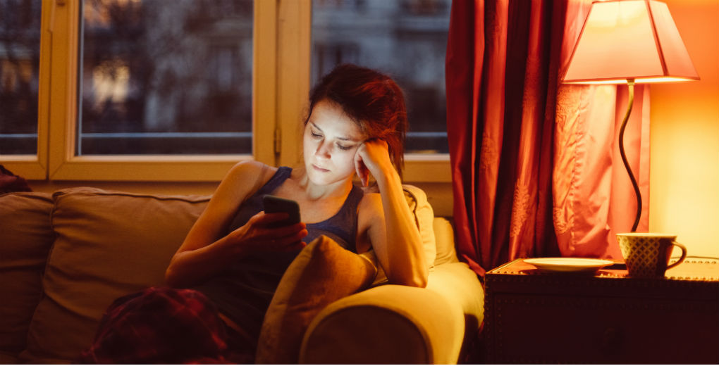 Woman in living room on phone for Find Insurance NI blog