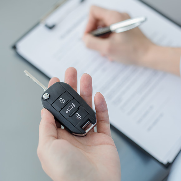 Handing over the keys to a new car to depict motor trade insurance by Find Insurance NI