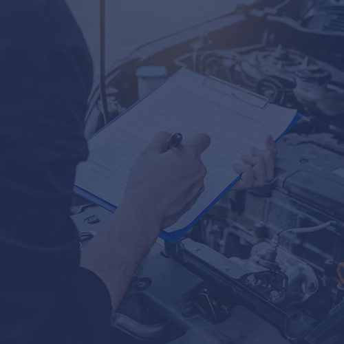 Man with clipboard carrying out an MOT on a car to depict motor trade insurance by Find Insurance NI