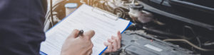 Man holding clipboard to complete MOT to depict motor trade insurance by Find Insurance NI