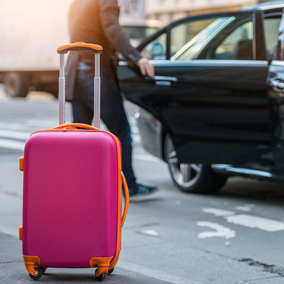 Man with suitcase getting into public taxi to depict Taxi insurance by Find Insurance NI