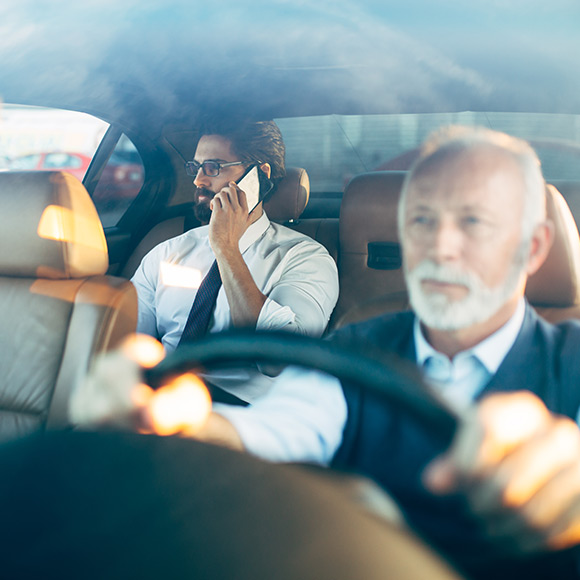 Taxi driver driving businessman to depict Taxi insurance by Find Insurance NI