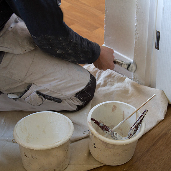 Painting doorframe to depict tradesman insurance by Find Insurance NI